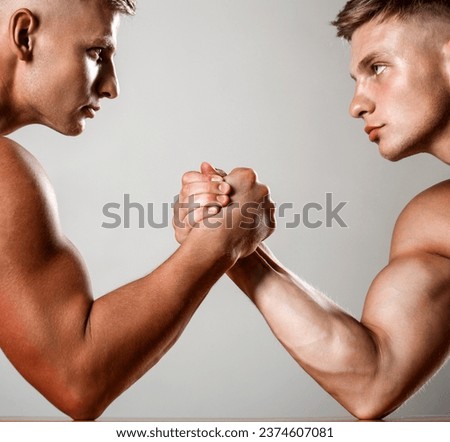 Muscular men measuring forces, arms. Hand wrestling, compete. Hands or arms of man. Muscular hand. Clasped arm wrestling. Two men arm wrestling. Rivalry, closeup of male arm wrestling. Two hands.
