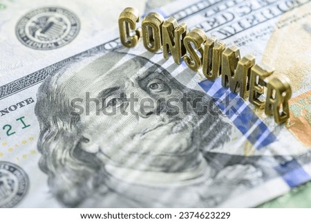 Consumer price index or CPI, consumer sentiment, economic concept : Word CONSUMER on US dollar, depicting CPI that measures consumer price changes, reflecting inflation's impact on the cost of living. Royalty-Free Stock Photo #2374623229