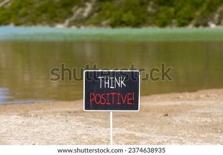 Think positive symbol. Concept words Think positive on beautiful chalk blackboard. Beautiful mountain lake background. Business, motivational think positive thinking concept. Copy space.