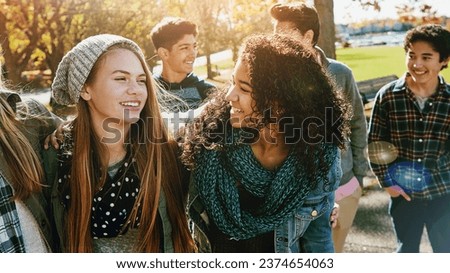 Teenager, walking and talking with friends in park, nature or social group outdoor together with funny conversation. Happy, teen and kids laugh at joke with best friend in community or relax in fall Royalty-Free Stock Photo #2374654063