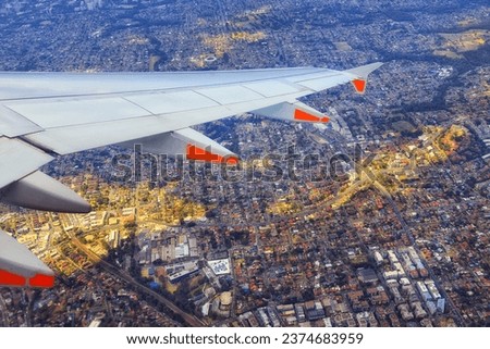 Airplane flying over Sydney West suburbs of Ryde from altitude over developed plains of Greater Sydney in Australia. Royalty-Free Stock Photo #2374683959
