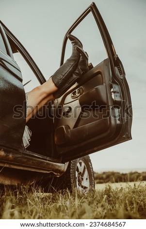 Beautiful female legs in cowboy boots are sticking out of the pickup truck. The concept of a western. Adventure concept. Royalty-Free Stock Photo #2374684567