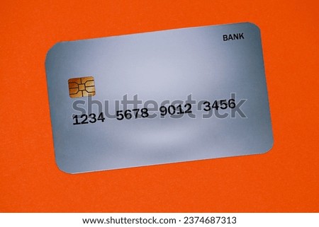 Picture on an orange background that has a gray bank card on it, a very rare card and a very attractive color.