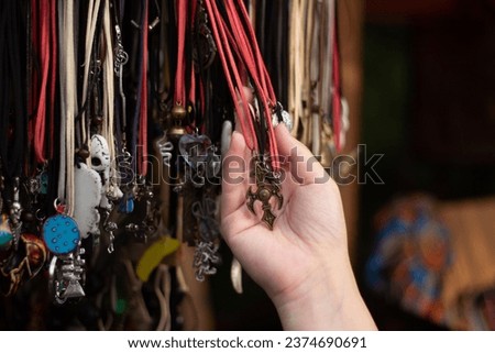 Woman choosing new authentic jewelry as birthday gift at folk craft festival. Celebrating Tbilisoba holiday. Day of city. Street fair. Female hand with metal silver bracelets. Hand made accessories