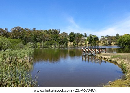 Beautiful scenery at Daylesford Lake with wooden viewing platform and  lush green trees in the background. The Natural attraction in Australia Victoria’s regional town is a popular sightseeing spot. Royalty-Free Stock Photo #2374699409