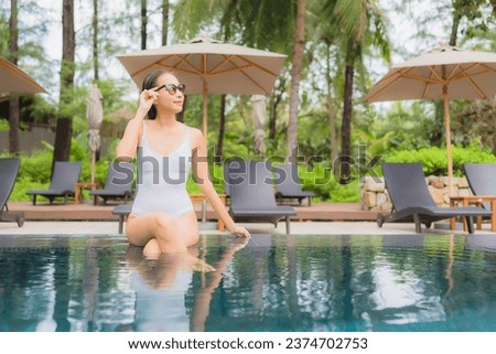 Portrait beautiful young asian woman relax smile leisure around outdoor swimming pool in hotel resort nearly sea beach