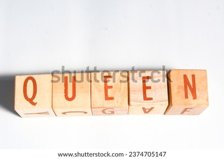 Wooden blocks make up the word "QUEEN" in English. Wooden block object