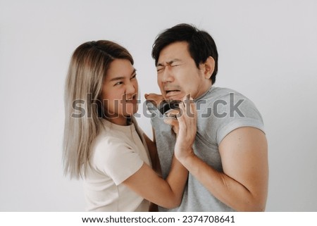 Domestic violence of asian wife hitting husband isolated on white.