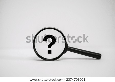 A close up of a magnifying glass with the word "?" (Question mark) on it