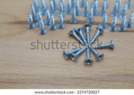 screws arranged on wooden background
