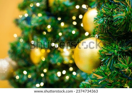 Golden christmas ball on pine tree branch green leaf blurred bokeh background merry christmas