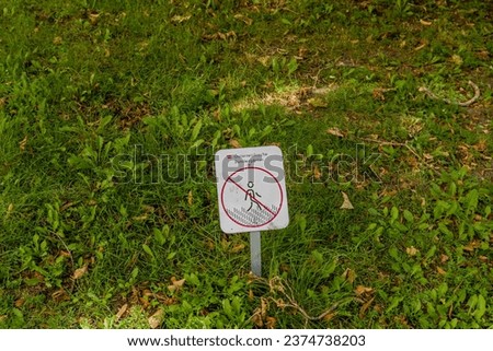 "Do not walk on grass" written in German on sign in lawn.