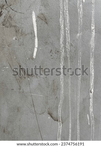 Rough textured light gray colored industrial wall flooring with white paint drop stains isolated on vertical photography template ratio.