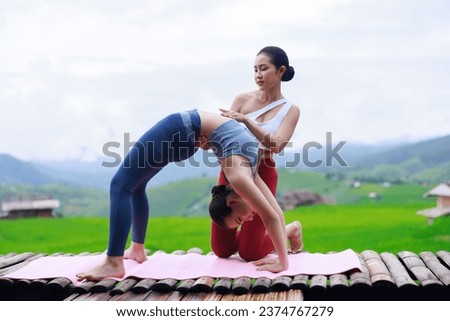 young girls is doing yoga training on balcony of resort with rice terraces, Ban Pa Bong Piang and mountains green over white sky in rainy season, Travel healthy lifestyle, enjoying in nature,