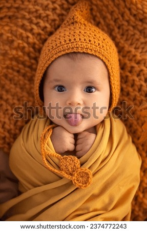 Adorable infant baby girl in autumn outfit showing tongue and looking at camerta, season holiday and childhood memories concept - Image Royalty-Free Stock Photo #2374772243