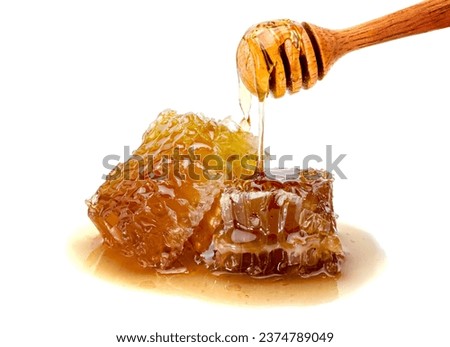Fresh Honeycomb slice and wooden honey dipper isolated on white background