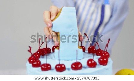Birthday cake with number one and cherries on a white background