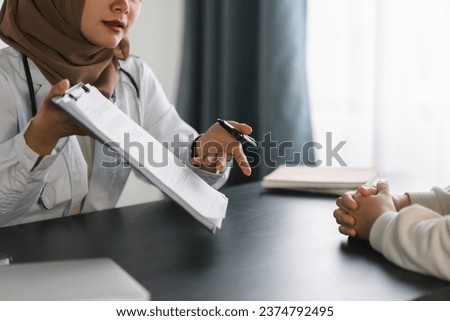 Young muslim female doctor in brown hijab headscarf having appointment consulting female patient in modern clinic hospital. Medical healthcare concept