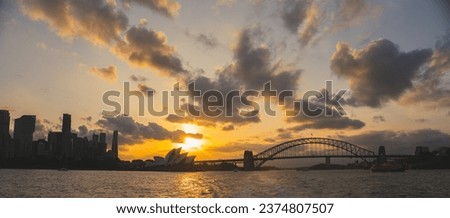 Cityscape image of Sydney, Australia with Harbour Bridge and Sydney skyline during sunset.
