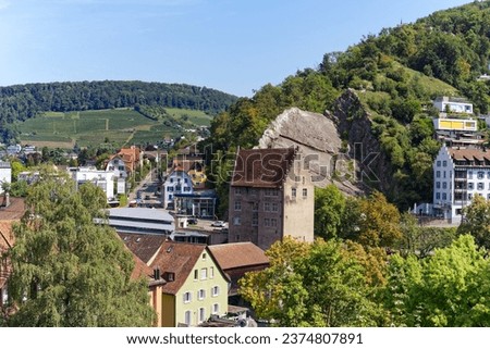 Scenic high angle view of the old town of Swiss City of Baden with stone tower and covered wooden bridge over Limmat River on a sunny summer day. Photo taken August 19th, 2023, Baden, Switzerland.