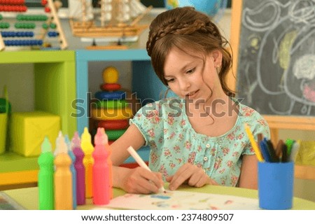 Close up portrait of cute girl drawing picture at home