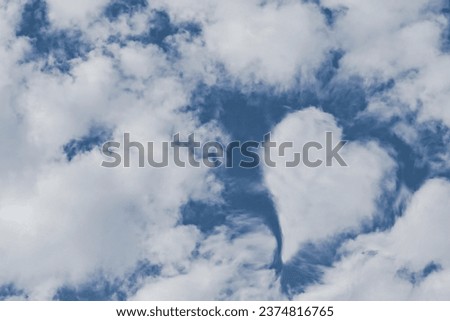 A heart as a symbol of love found in the clouds that can be used as a Valentine or wedding card. Natural colors of white clouds and blue sky.