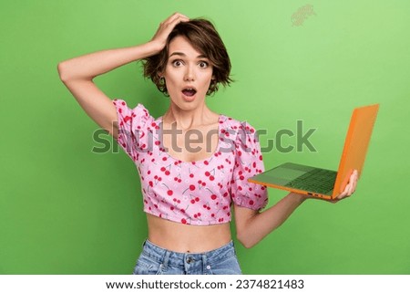 Photo of astonished speechless clueless woman bob hairstyle dressed pink blouse hold laptop arm on head isolated on green color background