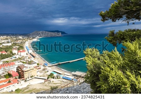 Crimea - May 2021. A line of beaches in the city of Sudak. View from the Genoese fortress on the Sudak Bay. Royalty-Free Stock Photo #2374825431