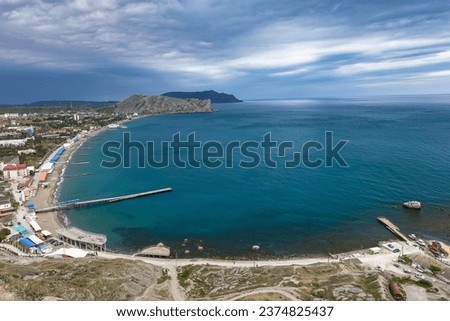 Crimea - May 2021. A line of beaches in the city of Sudak. View from the Genoese fortress on the Sudak Bay. Royalty-Free Stock Photo #2374825437