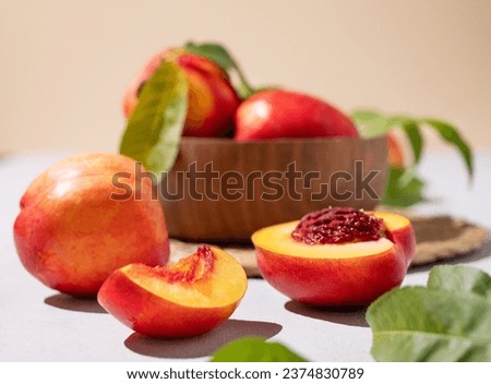 Juicy and sweet nectarines in a bowl on a light background close up. Healthy organic farm fruit concept. Vegetarian food. Royalty-Free Stock Photo #2374830789