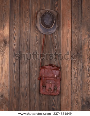 cowboy hat and leather bag on a wooden wall