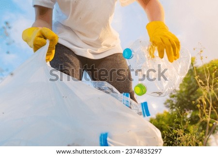 Volunteer teenage boys are holding garbage bags and Collecting plastic bottle waste at public parks for recycling, Reuse, and waste management concepts. Royalty-Free Stock Photo #2374835297