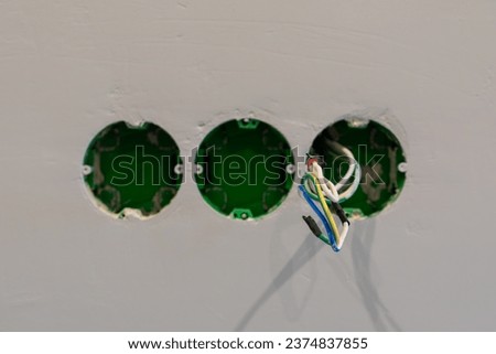 Electrical outlets holes on a grey background made with a texture of a plaster wall