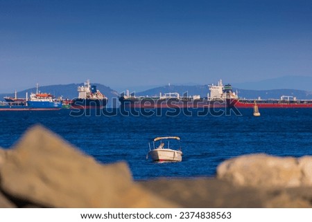 Ships and boats sail on the sea on a sunny day and silhouettes of people, a public place. Royalty-Free Stock Photo #2374838563