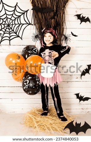 Pretty little girl dressing up as a witch in a Halloween setting