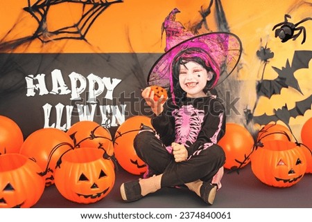 Pretty little girl dressing up as a witch in a Halloween setting