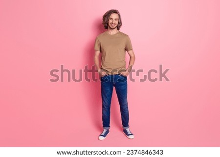 Full length photo of good mood guy with long haircut wear stylish t-shirt hold arms in pockets isolated on violet color background