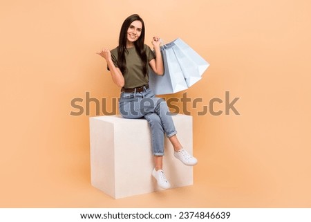Full length photo of sweet adorable lady wear khaki t-shirt rising bargains thumb empty space isolated beige color background