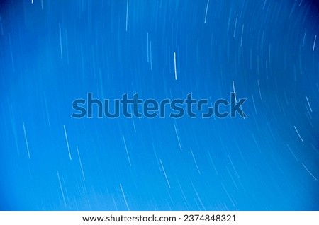 abstract long exposure of star trails in blue sky for background