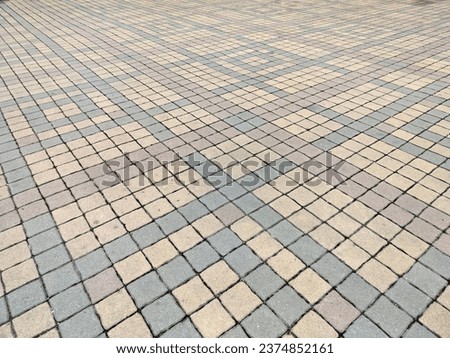 The courtyard is paved with tiles. Variety of colors, perfect horizontal picture, slanted view