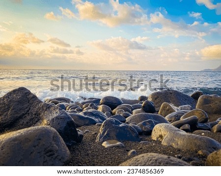Beautiful view of big rocks at beach shore with cloudy blue sky