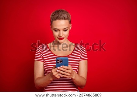 Photo of lovely cute gir addicted user hold phone write letter comment post wear stylish clothes isolated on red color background