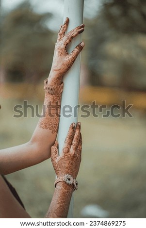 A modern bride showing her mehndi hands.
