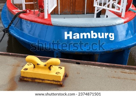Hamburg symbolized bei ship, water, bollard and word - Backside of a boat with word Hamburg
