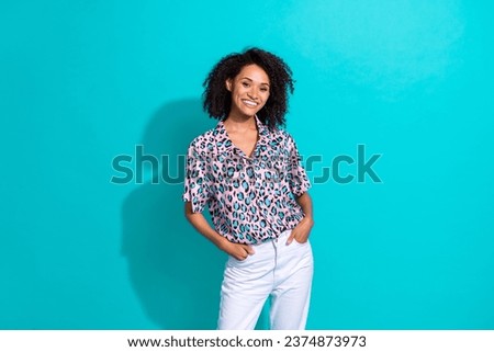 Photo of positive confident girl wear fashionable clothes hands in pockets isolated on cyan color background