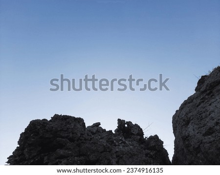 Cliffs and rocks against clear blue sky.