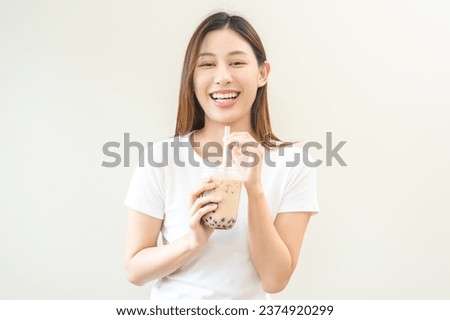 Beverage and food concept, Happy asian young woman hand holding plastic cup, glass of drink bubble, pearl milk tea with straw, cute girl drinking ice cold tea with tapioca boba ball popular in Taiwan. Royalty-Free Stock Photo #2374920299