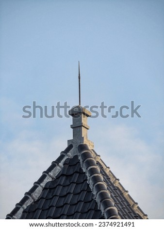 A photo of a lightning rod on a home's roof, used to direct lightning current to the ground without harming the building or its equipment and so reduce the risk of fire.