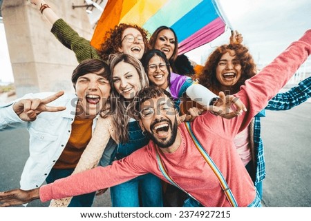 Diverse group of cheerful young people celebrating gay pride day - Lgbt community concept with guys and girls hugging together outdoors  Royalty-Free Stock Photo #2374927215
