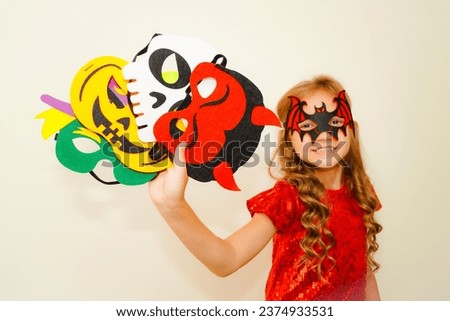 Unique child. Halloween. Child in Halloween carnival mask. The child made handmade felt masks for Halloween. Girl prepared for Halloween celebration. Bat, pumpkin, witch, skull and devil mask